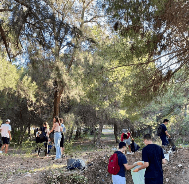 Des personnes marchant et se regroupant parmi les arbres.