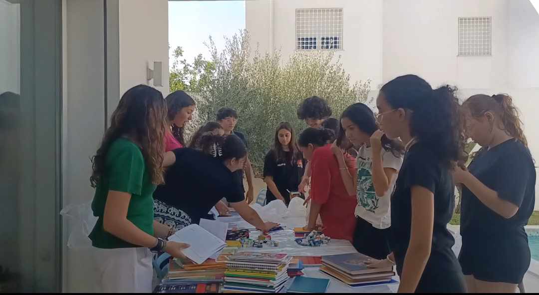 Des personnes organisant des papiers et du matériel sur une table.