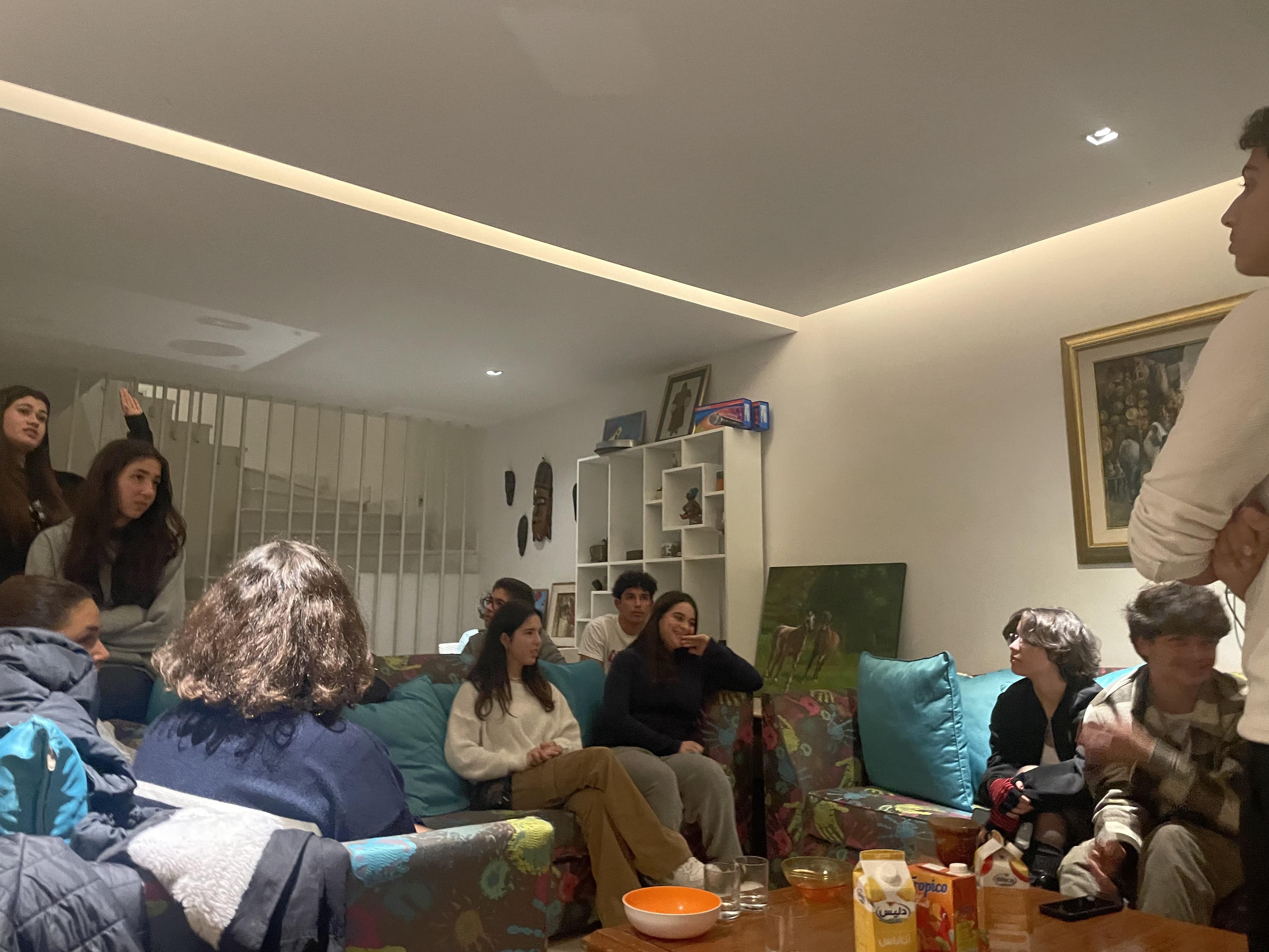 Un groupe assis autour d’une table dans un salon.