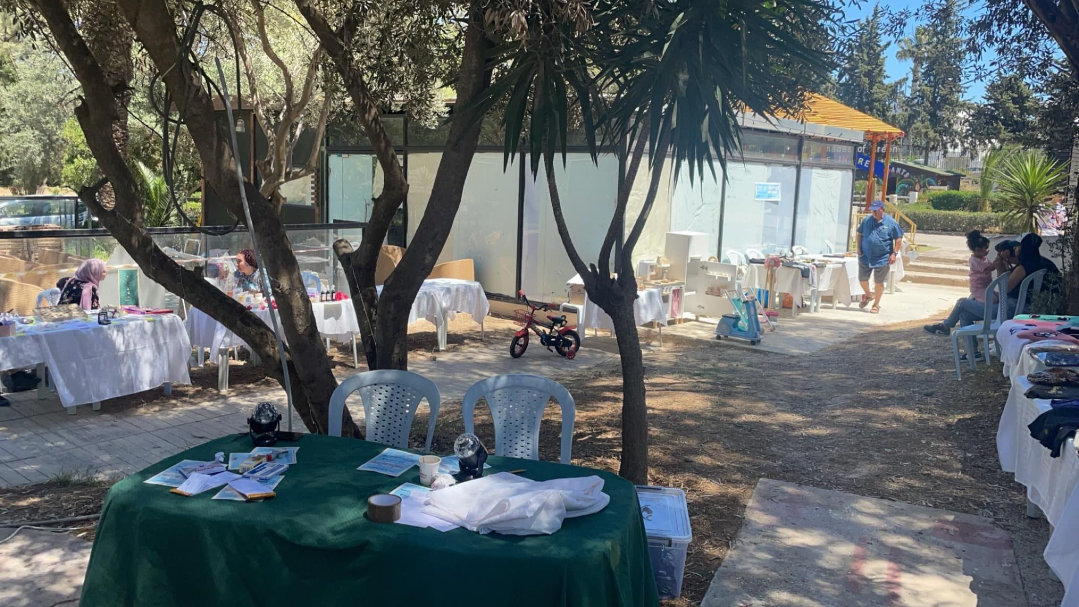 Des tables installées à l’extérieur, sous les arbres.