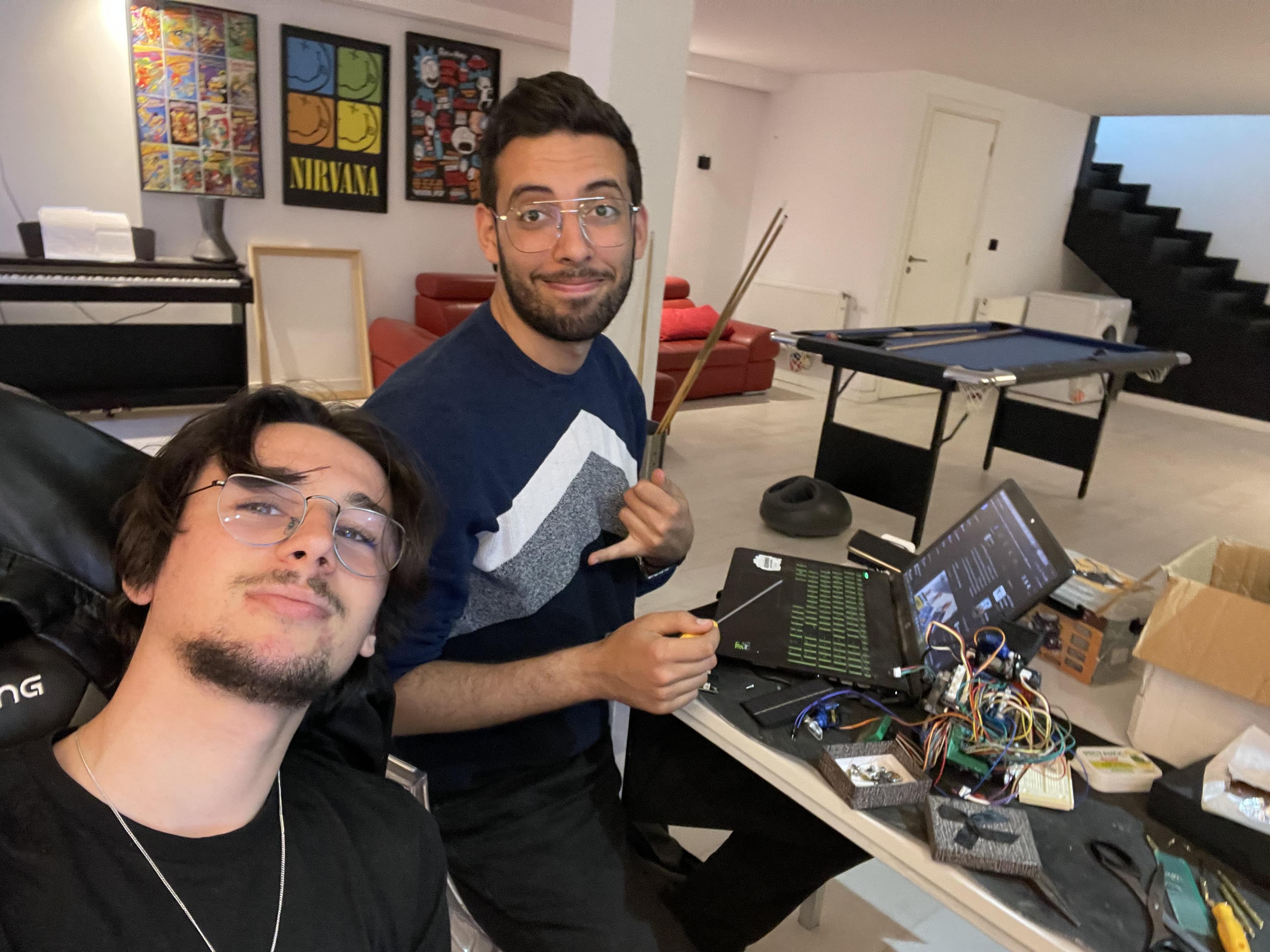 Deux personnes près d’un ordinateur portable et de l’électronique câblée du robot