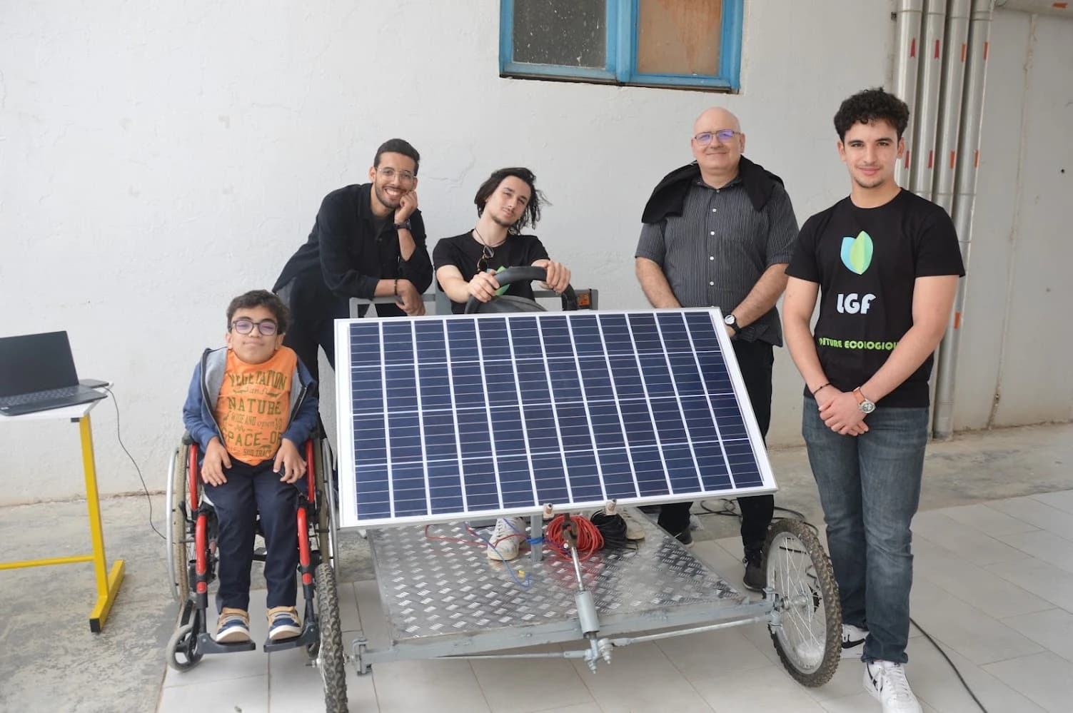 Un groupe derrière le panneau solaire placé à l’avant du prototype de véhicule